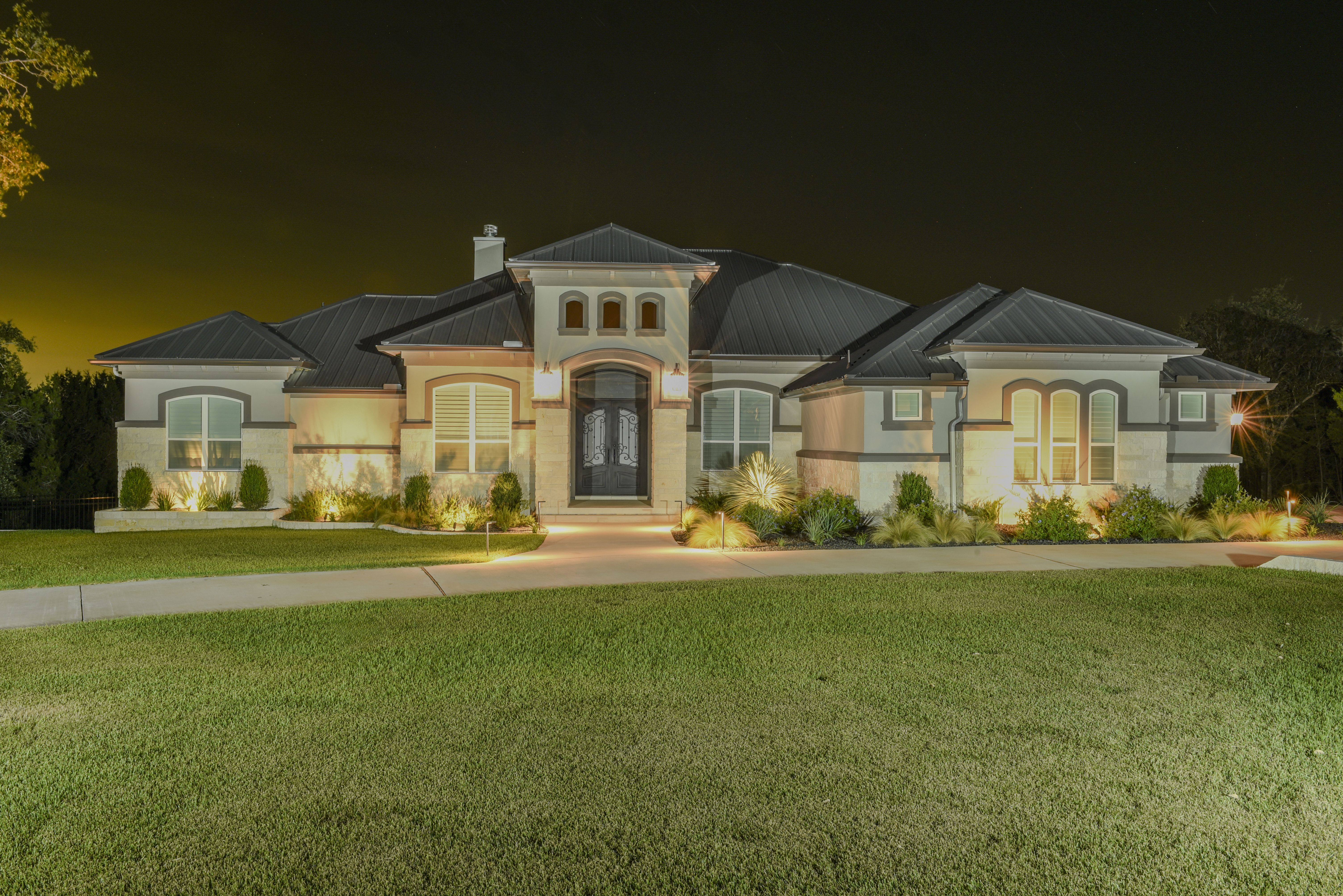 A home photographed at nighttime lit up due to a long camera exposure and a spotlight - Pinnacle Forensics crime scene photography training